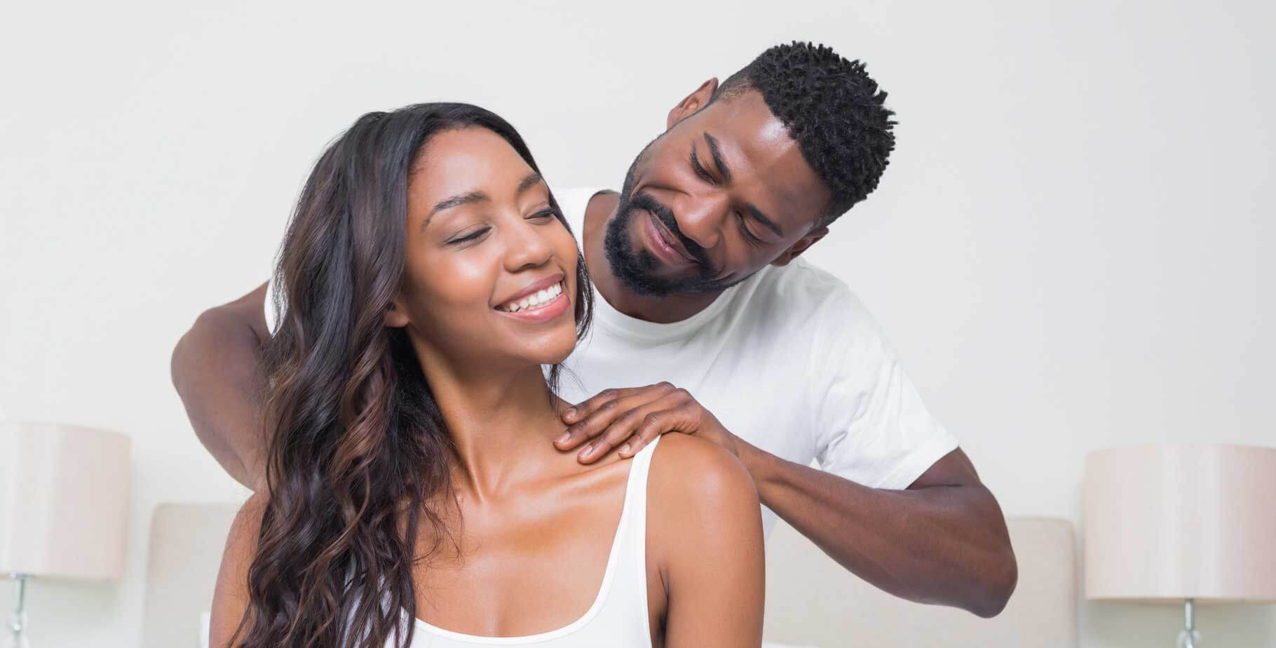 man massaging shoulders of woman