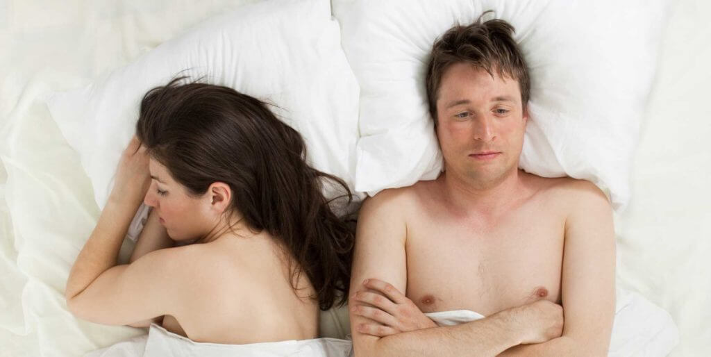 unhappy man in bed with woman