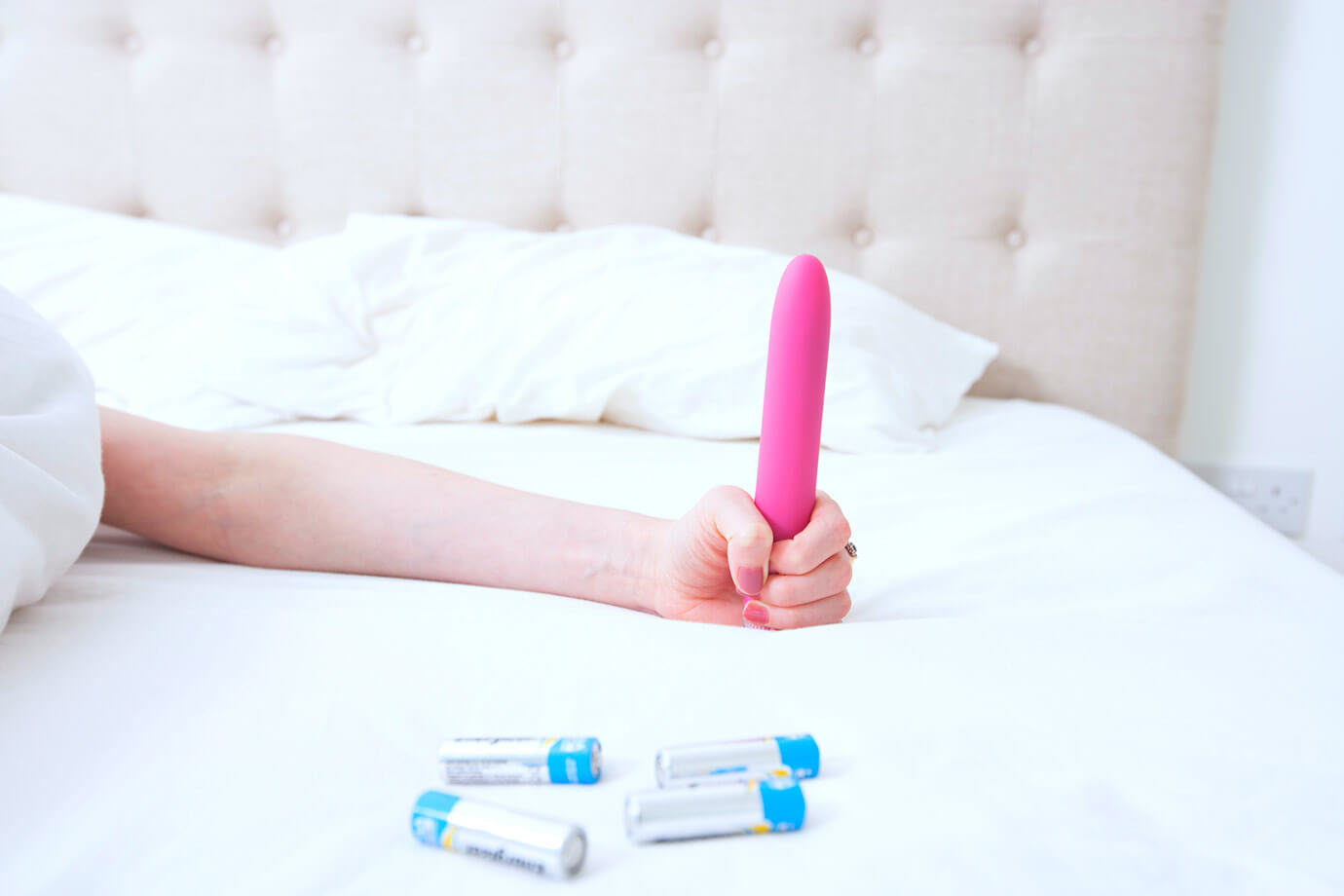 woman in bed holding vibrator