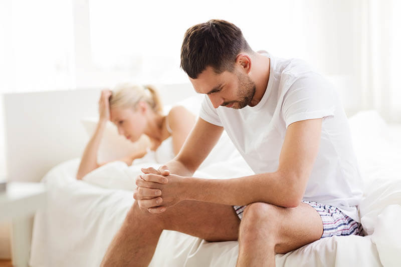 Unhappy couple having problems at bedroom