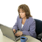 A mature female executive working at her laptop.