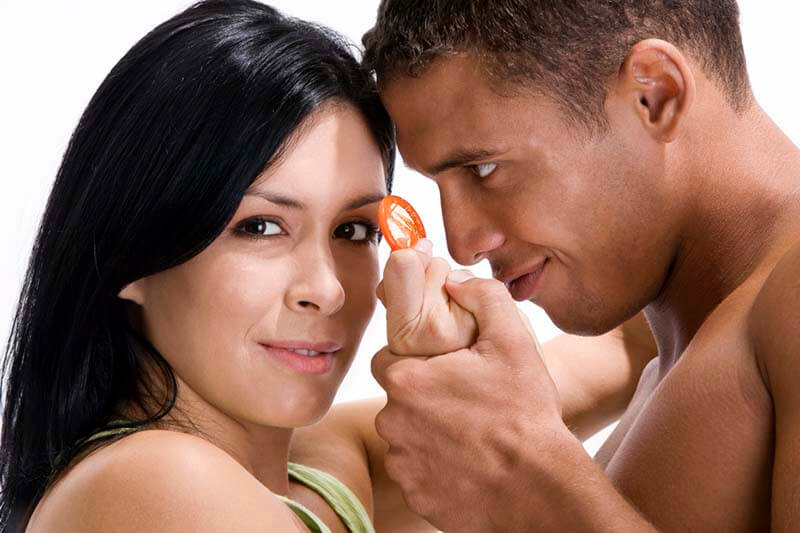 Close-up of a young couple holding a condom