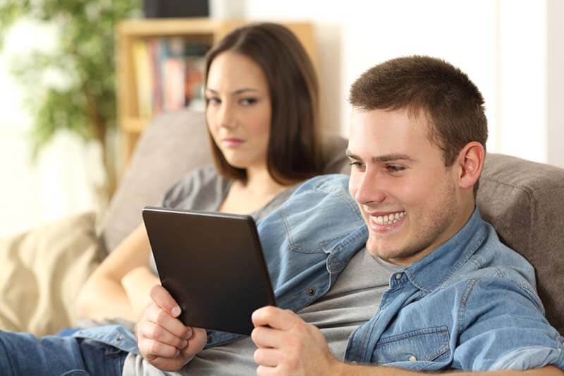 unhappy wife while husband looks at ipad