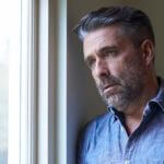 worried middle aged man at window