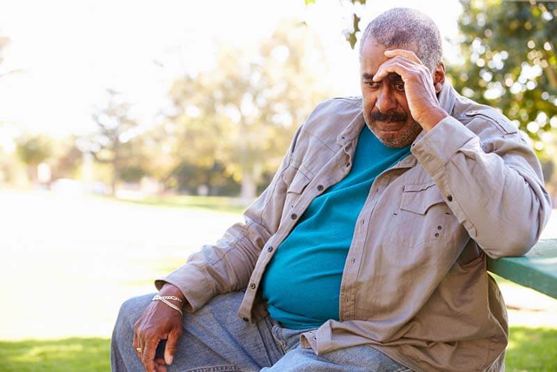 unhappy Senior Man Sitting Outside