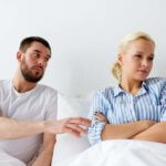 unhappy couple having conflict in bed at home