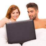 couple watching a movie in bed
