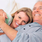Senior couple embracing lying in bed