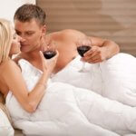 Couple drinking on the bed in bedroom