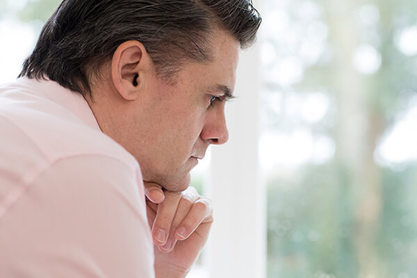 Worried Mature Man At Home looking out window