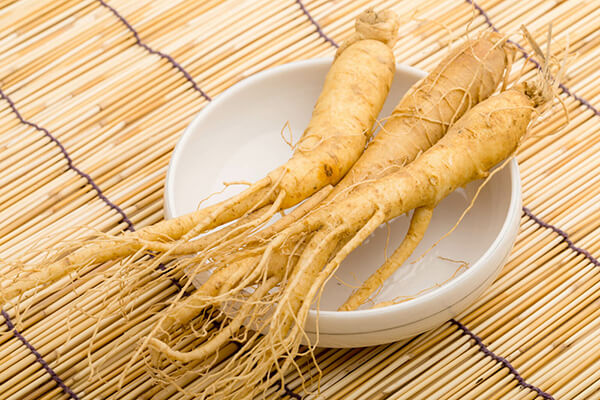 3 ginseng roots in a bowl on a table